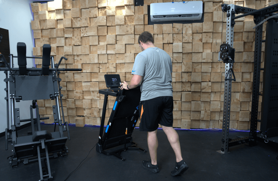 Our tester folding up the MERACH T12 Foldable Walking Treadmill following a workout