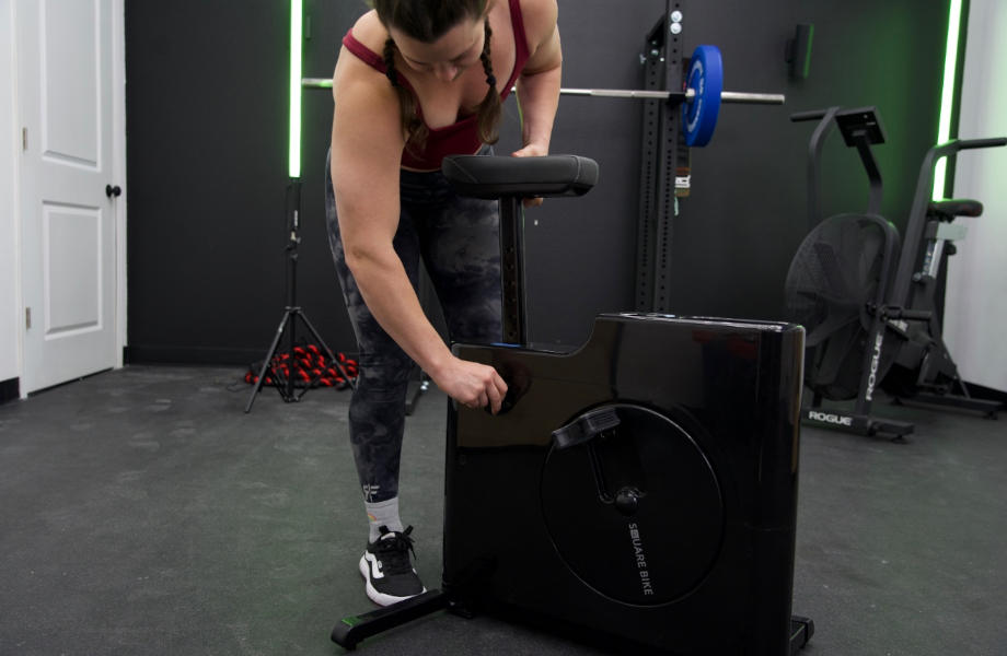 A woman adjusts the seat height on a Sharper Image Square Bike