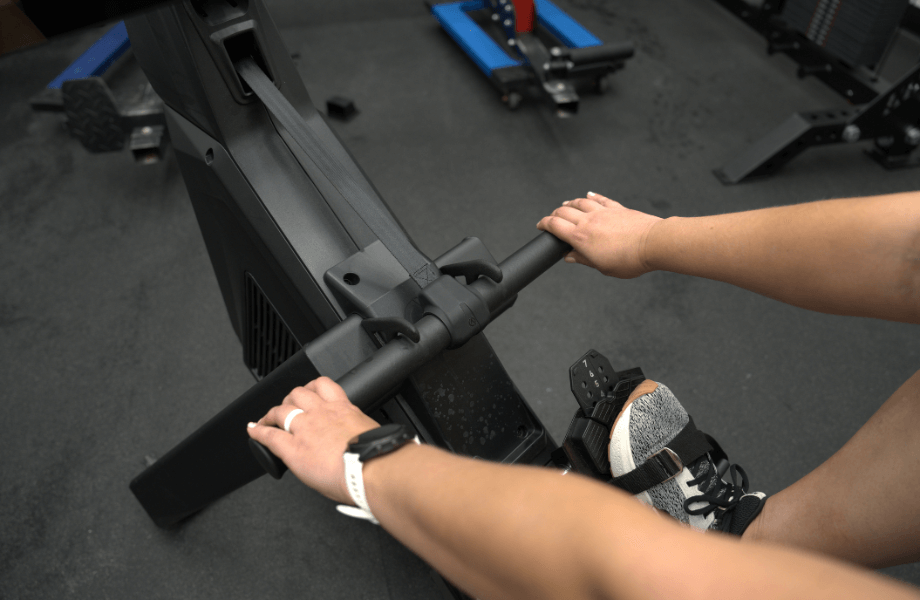 Our tester grabbing the handlebar of an Aviron rowing machine