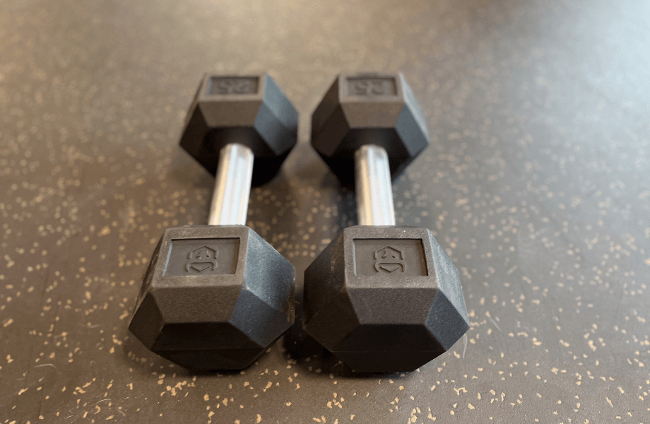 Two Iron Bull Rubber Hex Dumbbells resting on home gym flooring