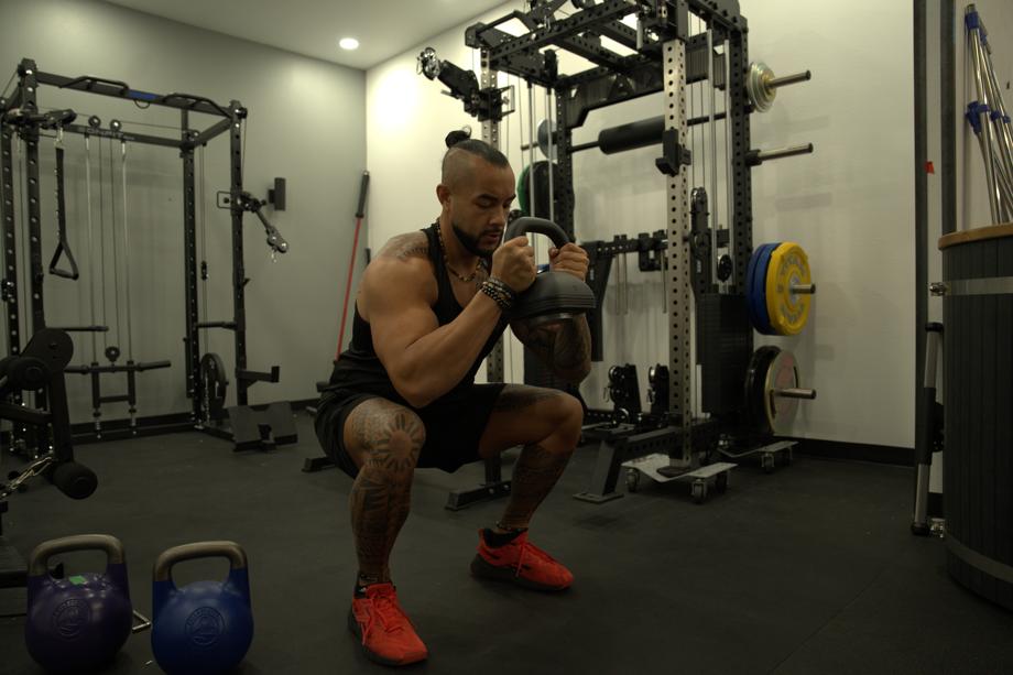 A man does goblet squats with an Ironmaster Quick-Lock Adjustable Kettlebell