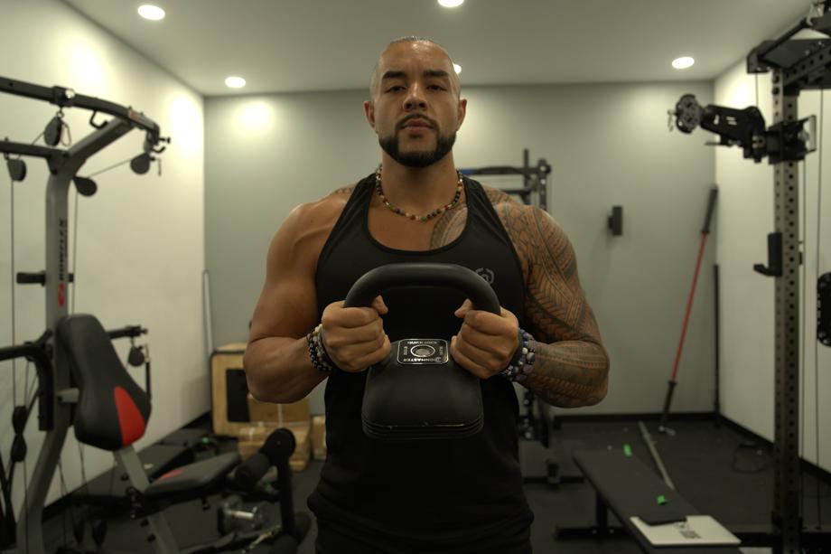 Stephen Sheehan, CPT, CNC, poses with an Ironmaster Quick-Lock Adjustable Kettlebell