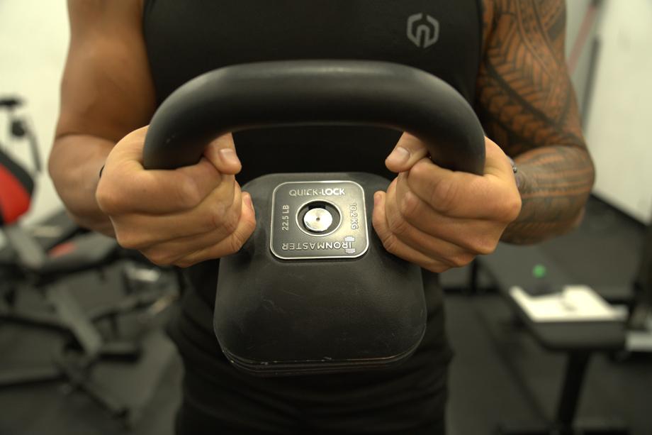 A person holds up an Ironmaster Quick-Lock Adjustable Kettlebell