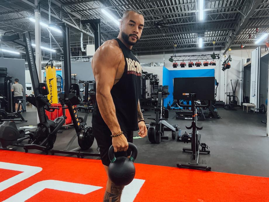Stephen Sheehan, CPT, CNC, stands in a gym holding a Giant v3 24kg Kettlebell