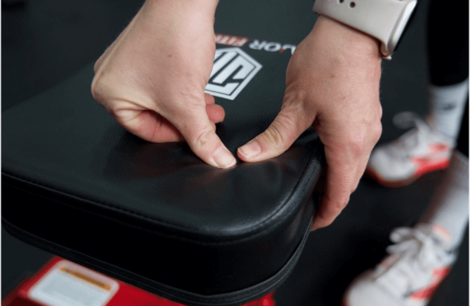 Our tester examining the back pad thickness and firmness on the Major Fitness Adjustable Bench