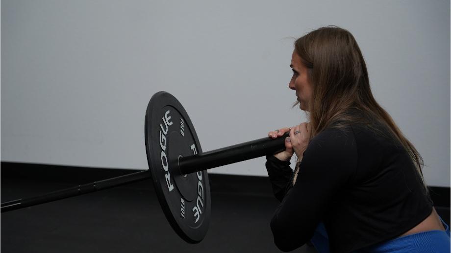 A woman doing a landmine lunge with the Major Fitness Barbell