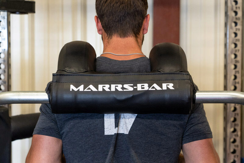 Rear view of man standing with the Marrs-Bar on his shuolders