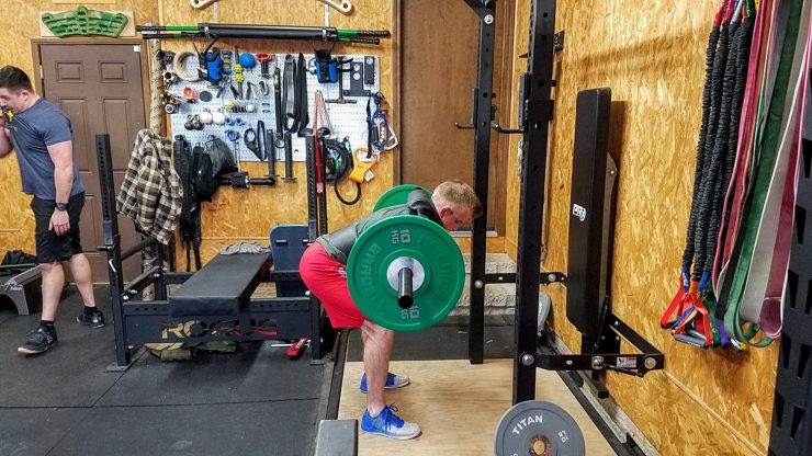 Someone using The Rogue SB-1 Safety Squat Bar in a home gym for good mornings