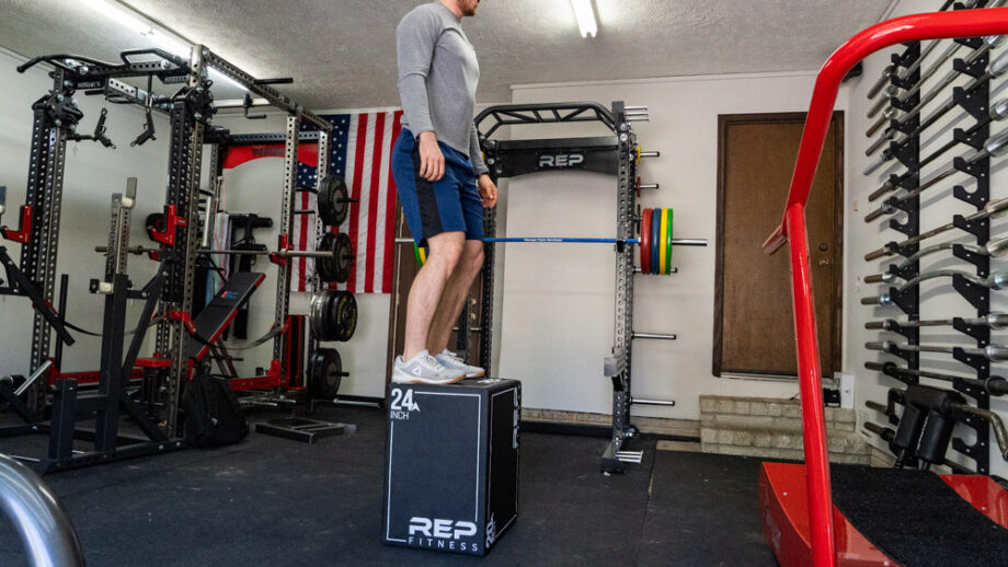 man standing on the Rep Fitness 3-in-1 Soft Plyo Box in a garage gym