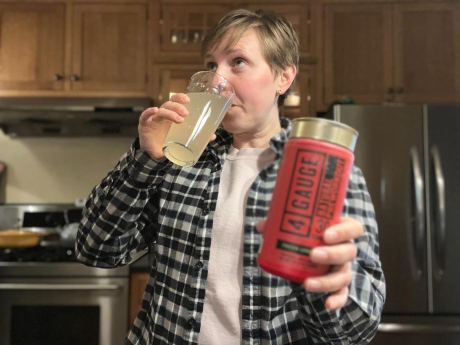 A woman drinking 4 Gauge Pre-Workout