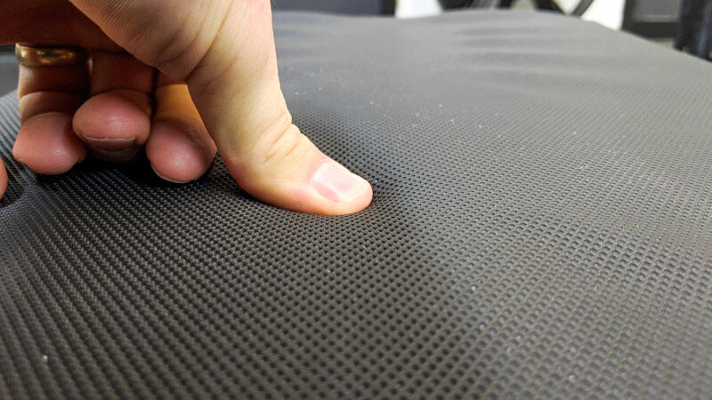 Close up shot of a thumb pressing into the vinyl on the REP Fitness FB-5000 Flat Bench pad