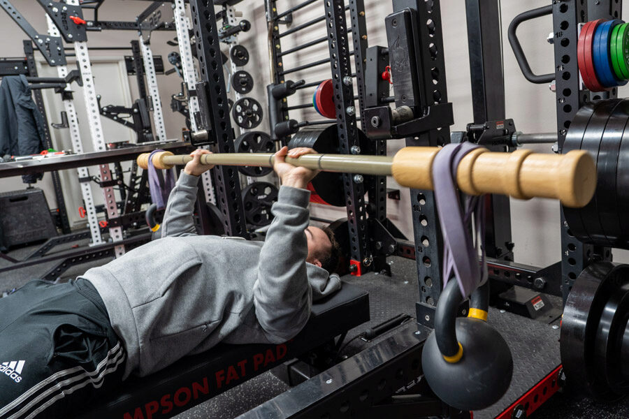 coop performing a bench press with the BandBell Earthquake Bar