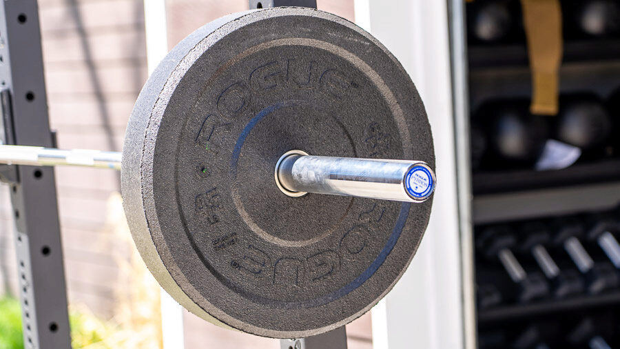 A Rogue US MIL Spec Bumper Plate on a barbell outdoors 