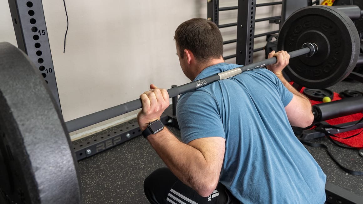 coop squatting with a barbell while wearing training shoes