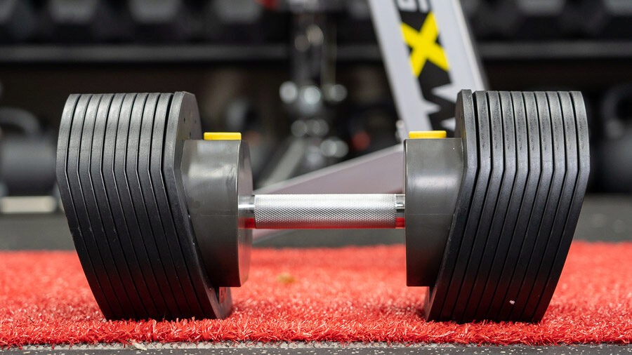 Main photo of the adjustable dumbbells sitting on the ground. 