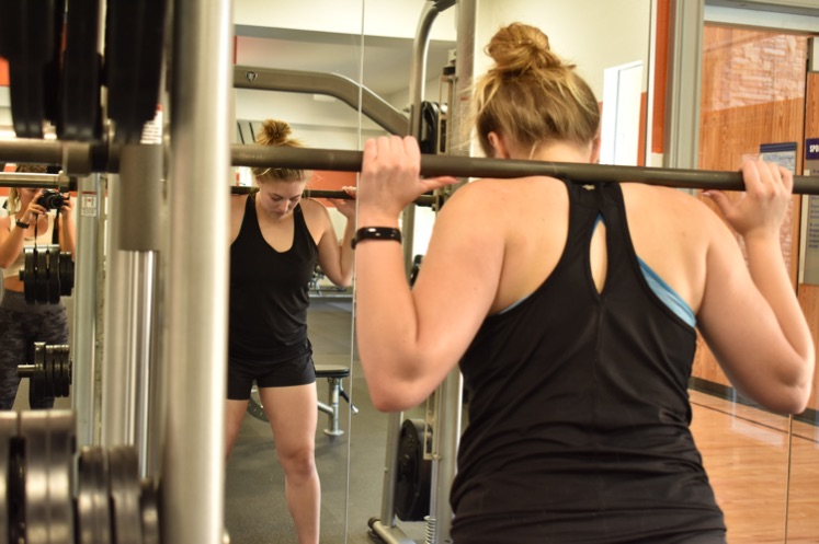 girl wearing the Fitbit Inspire 2 while squatting