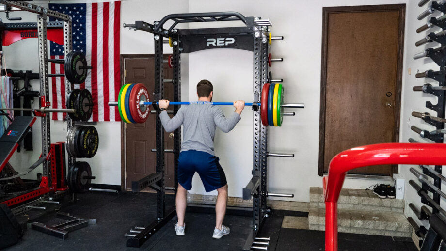 man squatting with the Rep Fitness HR-5000 Half Rack
