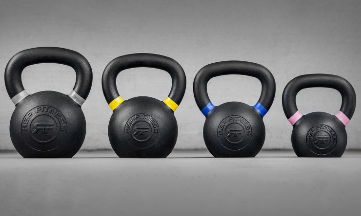 Four REP Fitness iron kettlebells, color-coded for sizing