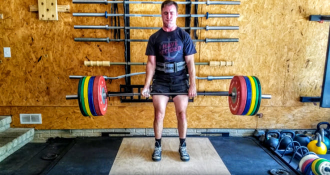 coop performing a deadlift with a barbell and bumper plates