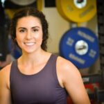 Amanda smiling in a gym