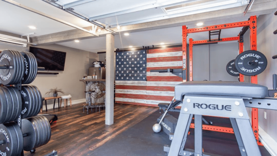 Home gym with Rogue Fitness equipment and an American Flag wood paneled wall