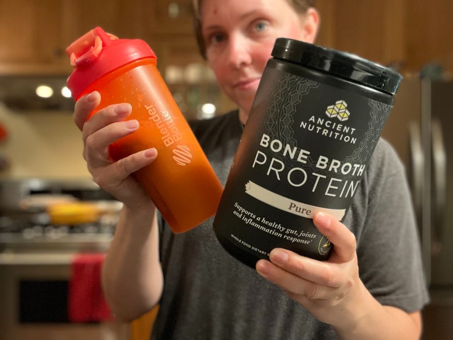 Woman holding Ancient Nutrition Bone Broth Protein shake