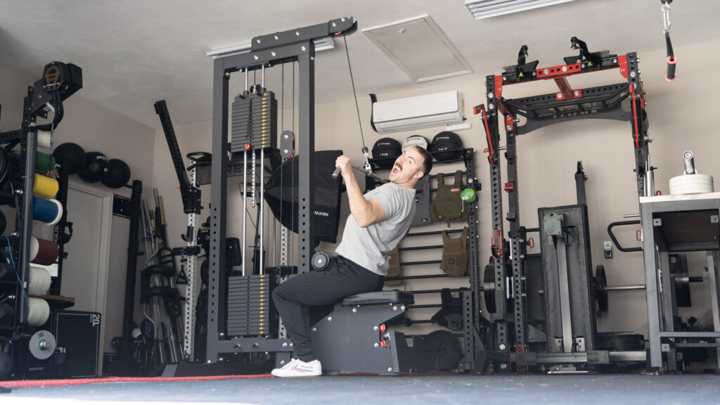 Coop setting up for a lat pull-down exercise on the Titan Fitness Lat Tower