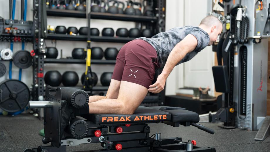 Coop does a hamstring curl on the Freak Athlete Hyper GHD bench