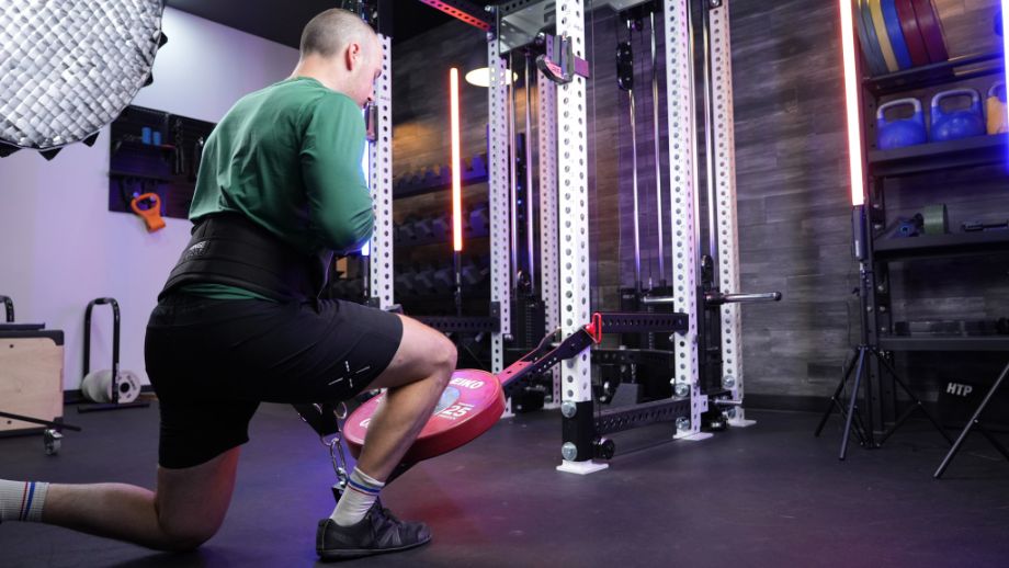 Man performing lunges with Fringe Sport belt squat attachment