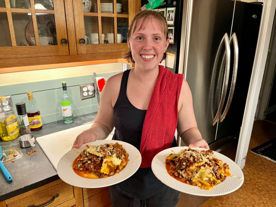 Woman holding two dinner plate with pasta