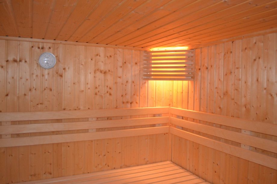 Wide shot inside a sauna with infrared light in top corner