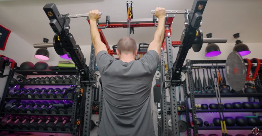 Man in the locked out position on an overhead press using jammer arms