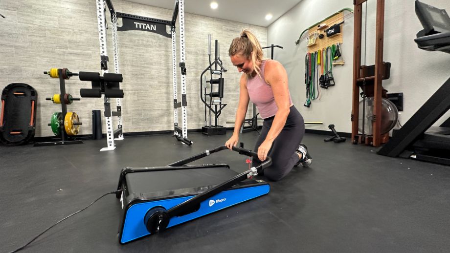 Woman folding down handrail of LifePro PacerMini treadmill