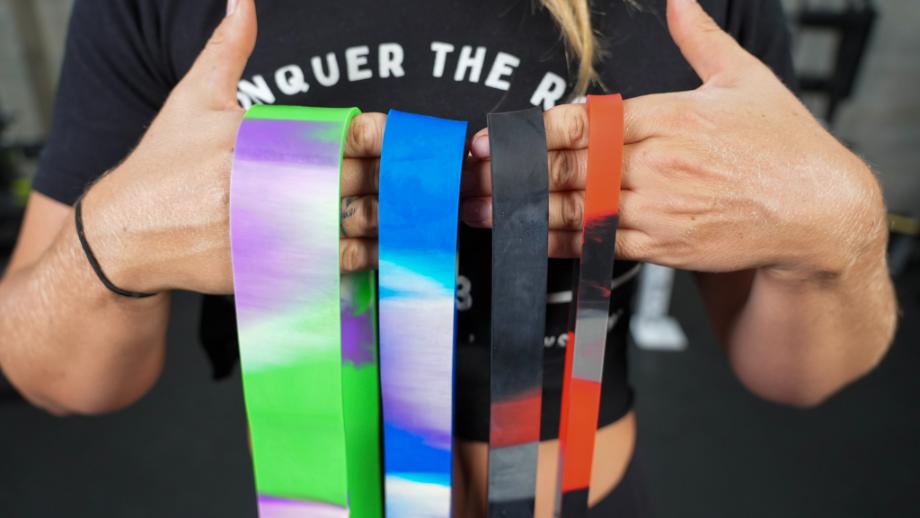 Hands holding up the whole rainbow of Living.Fit Camo Bands