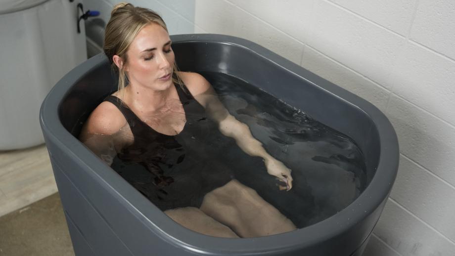 A woman takes an ice bath in the Nordic Wave cold plunge tub.