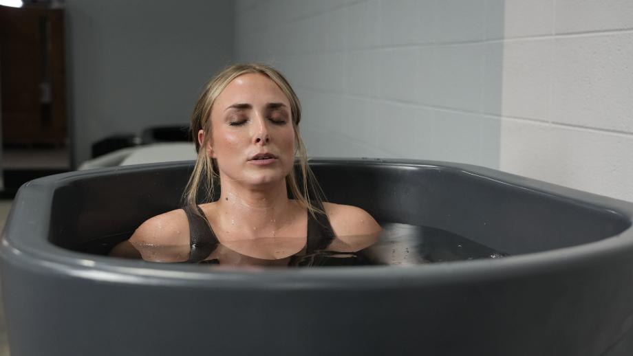 A woman performing a breath technique in the Nordic Wave cold plunge tub.