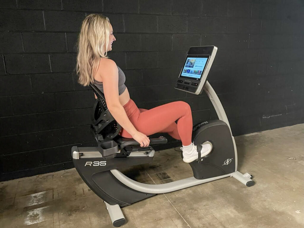 woman smiling while using the nordictrack commercial r35 recumbent bike