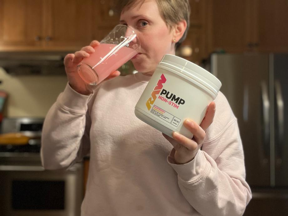 A woman drinking RAW Nutrition Pump Pre-Workout.