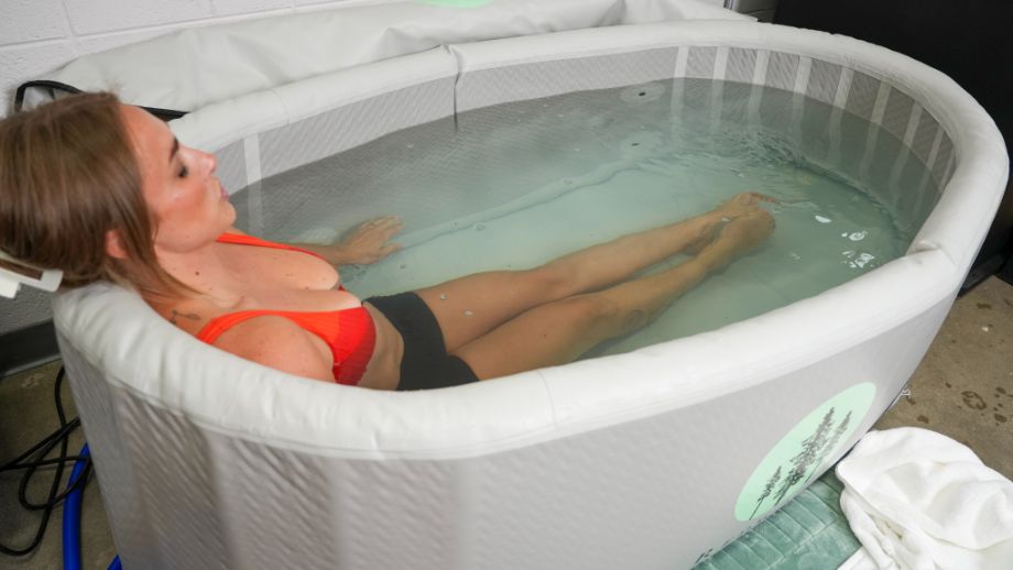 Woman sitting with legs straight in the Redwood Outdoors Yukon tub