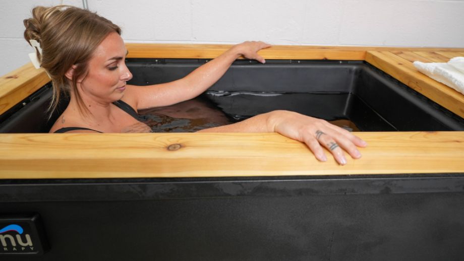 Woman in Renu Therapy Cold Stoic with hands out on the edge of tub