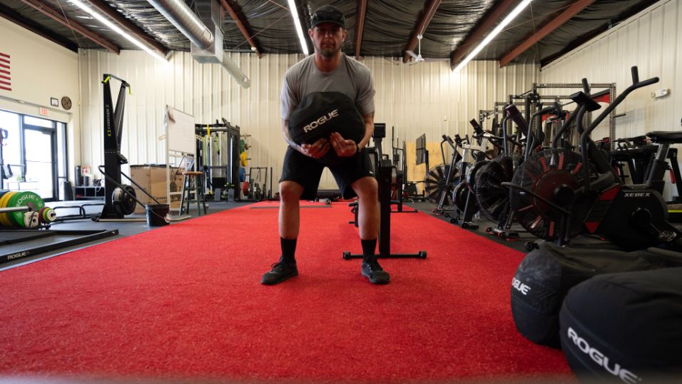 man carrying aRogue Strongman Sandbag