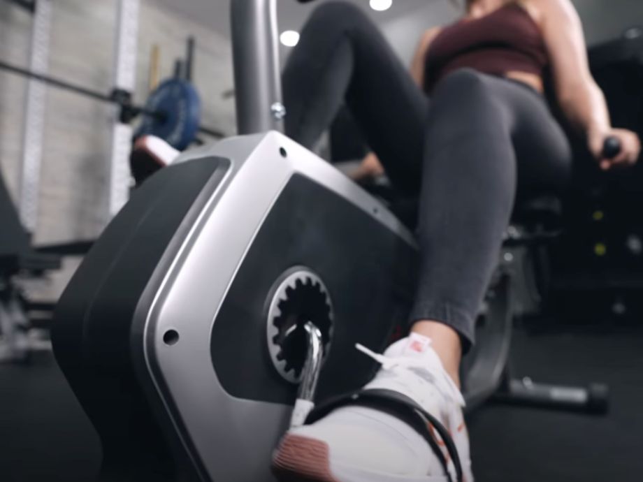 Close up view of a person's feet peddling on the Sunny Health and Fitness Essential Recumbent Bike.