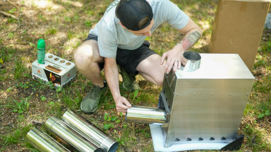 Man assembling the sauna stove for the SweatTent