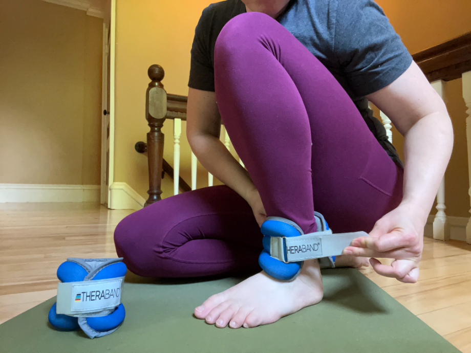 Woman putting on Theraband ankle weights