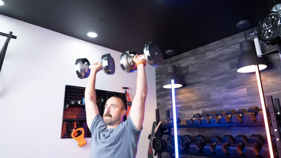 Man overhead pressing with Trulap adjustable dumbbell