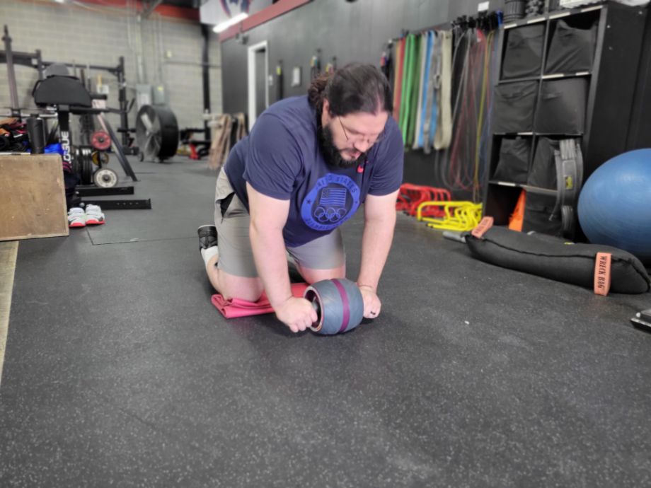 Man at the start of an ab wheel exercise