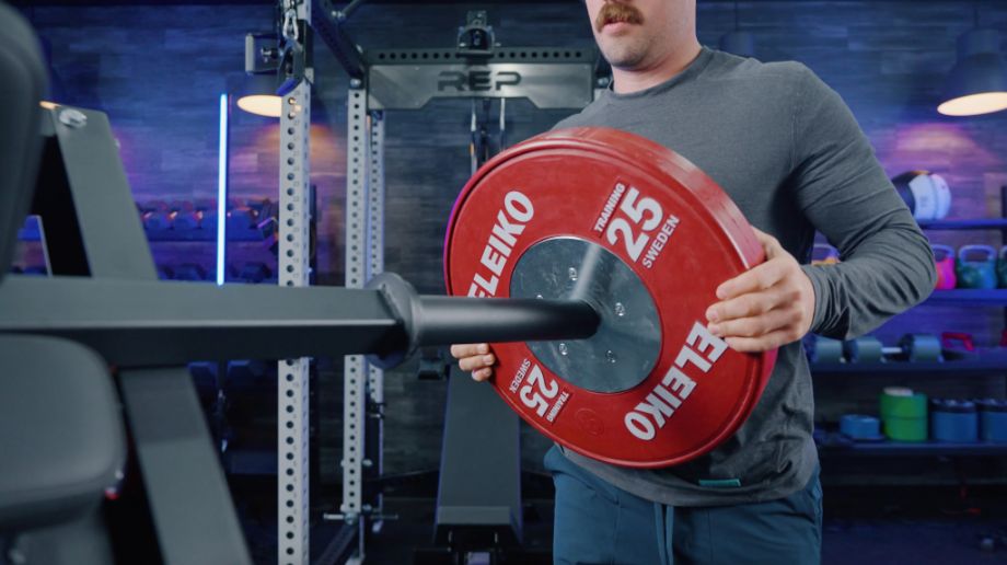 Man adds a weight plate to the Titan Leg Press Hack Squat