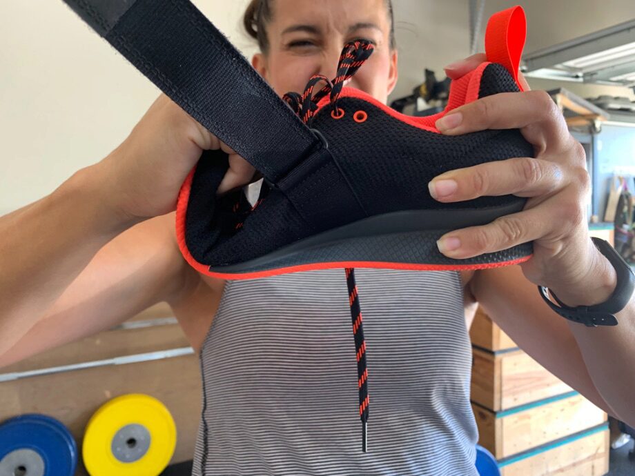 Woman twisting the Adidas Adipower 2 weightlifting shoes to demonstrate the flexibility of the sole