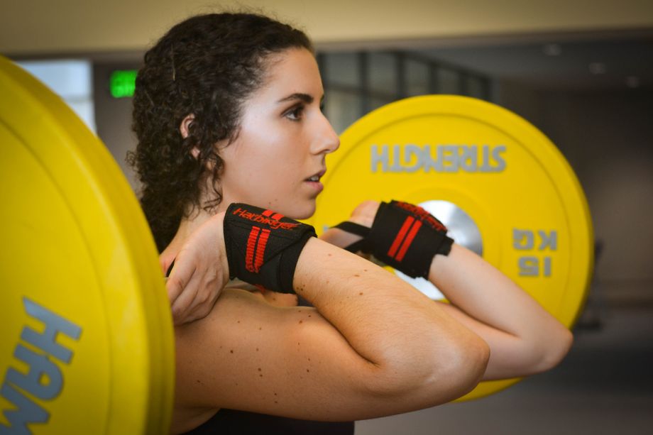 A woman holding a barbell in the front rack position