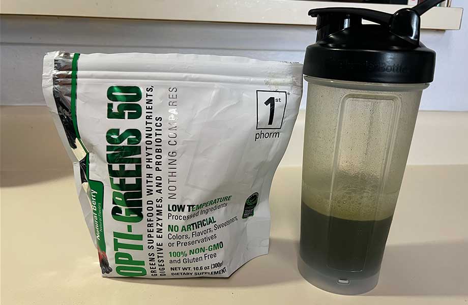 A bag of Opti-Greens 50 on a counter with a shaker bottle